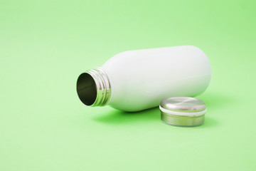 White thermo bottle on a green background