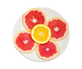Fototapeta na wymiar Round slices of red grapefruits and orange on white dish