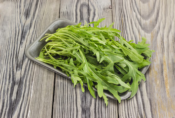 Arugula in foam food container on an old wooden surface