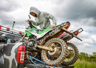 Two dirt bike motorcycles on the back of the camo truck © Georgii