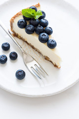 New York Cheesecake With Fresh Blueberries And Mint On White Background, selective focus. Blueberry Cheesecake