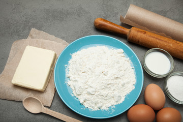 Fototapeta na wymiar Organic ingredients for making dough on a gray background.