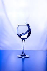 a glass of water bright light splashes background with reflection neon