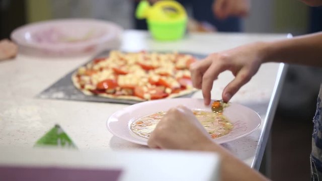 a teenager eats a soup with a spoon from a plate.