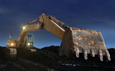 excavator digging at sunset