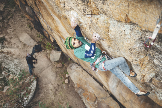 High angle view of climber reaching across for handhold on rock face in granite wall