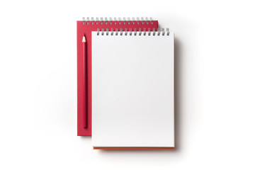 Design concept - Top view of red spiral notebook and color pencil collection isolated on white background for mockup