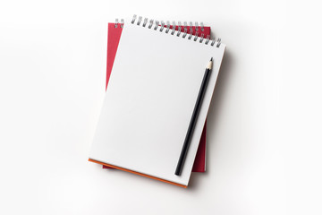 Design concept - Top view of red spiral notebook and color pencil collection isolated on white background for mockup