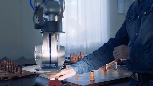 Robot and a chess player playing chess.