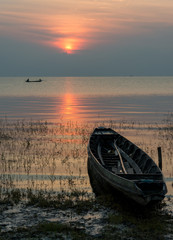 Beautiful sunrise with boat and fisherman in the lake at Pakpra.