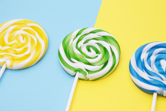 spiral colored round lollipops on yellow and blue background