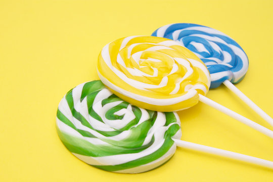 spiral colored round lollipops on yellow background