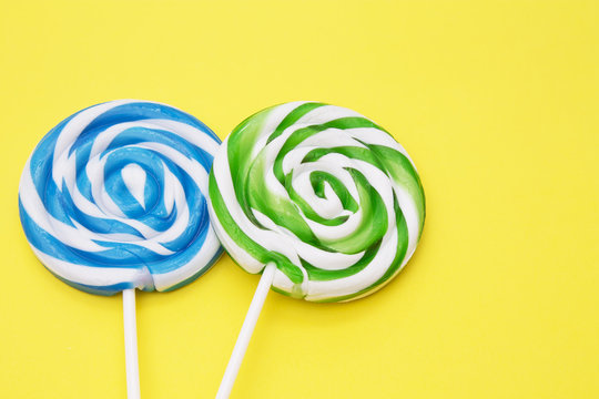 spiral colored round lollipops on yellow background