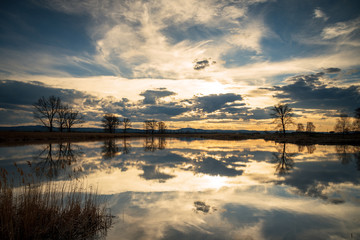 Naklejka na ściany i meble Sunset over lake and beautiful clouds.