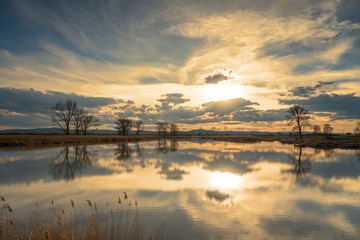 Obraz na płótnie Canvas Sunset over lake and beautiful clouds.
