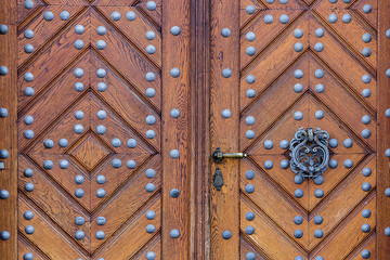 Fototapeta premium Wooden door with handle ring and iron rivets