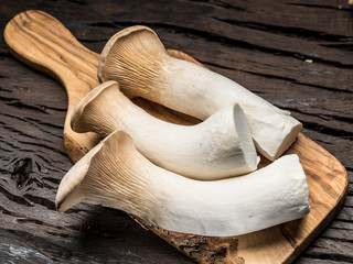 King oyster mushrooms on the wooden background.