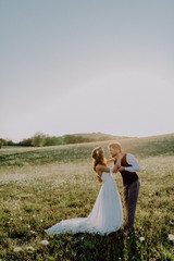Beautiful bride and groom at sunset in green nature.