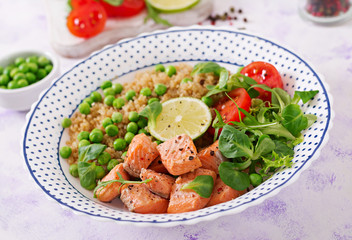 Healthy dinner. Slices of grilled salmon, quinoa, green peas, tomato, lime and lettuce leaves