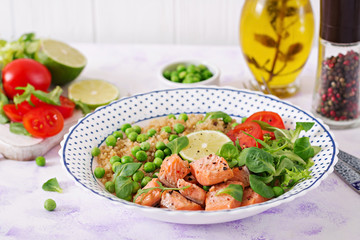 Healthy dinner. Slices of grilled salmon, quinoa, green peas, tomato, lime and lettuce leaves