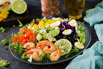 Healthy salad plate. Fresh seafood recipe. Grilled shrimps and fresh vegetable salad - avocado, tomato, black beans, red cabbage and paprika. Grilled prawns. Healthy food.