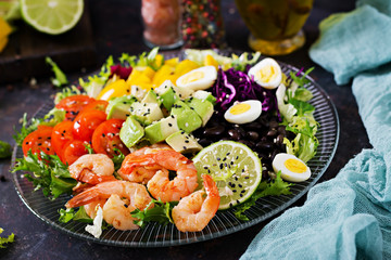 Healthy salad plate. Fresh seafood recipe. Grilled shrimps and fresh vegetable salad - avocado, tomato, black beans, red cabbage and paprika. Grilled prawns. Healthy food.