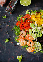 Healthy salad plate. Fresh seafood recipe. Grilled shrimps and fresh vegetable salad - avocado, tomato, black beans, red cabbage and paprika. Grilled prawns. Healthy food. Flat lay. Top view