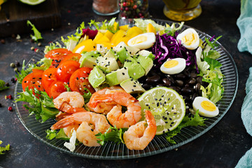 Healthy salad plate. Fresh seafood recipe. Grilled shrimps and fresh vegetable salad - avocado, tomato, black beans, red cabbage and paprika. Grilled prawns. Healthy food.