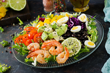 Healthy salad plate. Fresh seafood recipe. Grilled shrimps and fresh vegetable salad - avocado, tomato, black beans, red cabbage and paprika. Grilled prawns. Healthy food.