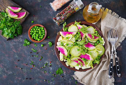 Salad from radish, cucumber and lettuce leaves. Vegan food. Dietary menu. Top view. Flat lay