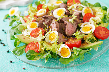 Warm salad from chicken liver, avocado, tomato and quail eggs. Healthy dinner. Dietary menu.