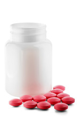 Medical pink pills and white bottle on white isolated background. Concept of healthcare and medicine.