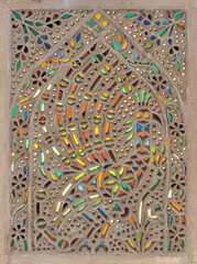 Perforated stucco window decorated with colorful stain glass with geometrical circular patterns, one of the traditions of the Ottoman era