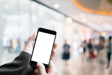 A man using smartphone with blank screen in a market or department store, closeup image. For Graphic display montage.