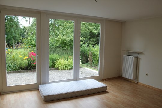 leerer raum mit einer matratze und ausgang in den garten