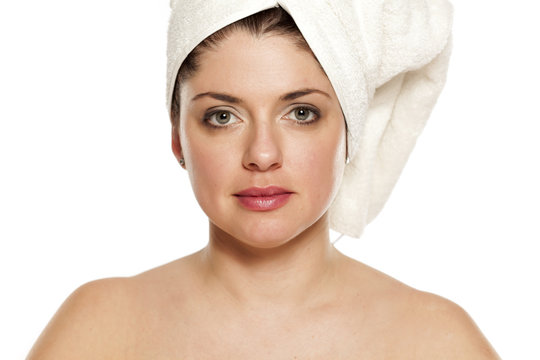 Young beautiful woman with towel on hr head on white background
