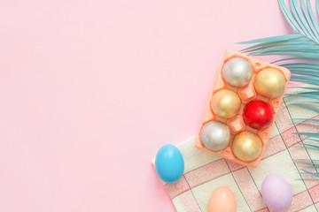 Flat lay top view colorful easter egg painted in pastel colors composition and spring flowers on pink pastel color background. Easter day background top view with copy space.