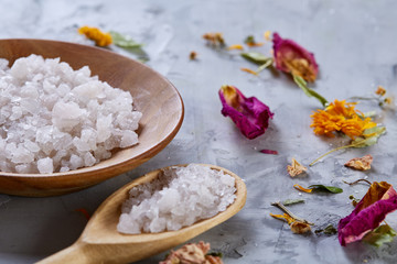 Composition of spa treatment on white background. Sea salt and flowers background, close up, top view, selective focus.