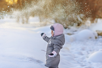 Fototapeta na wymiar Cute child playingCute child playing with snow with snow