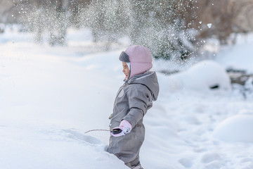 Fototapeta na wymiar Cute child playingCute child playing with snow with snow
