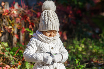 Child in autumn orange leaves.