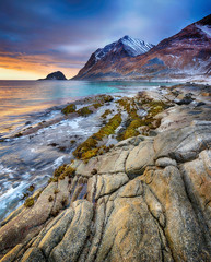 Beautiful sunset Norway landscape of picturesque stones on the arctic beach of cold Norwegian Sea