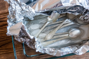 Cleaning dishes. Melchior spoons and forks in foil
