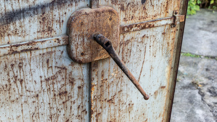 Open old rusty metal door with big lever
