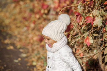 Child in autumn orange leaves.
