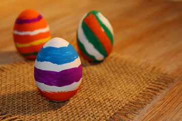 красивые разноцветные пасхальные яйца лежат на  деревянных досках         