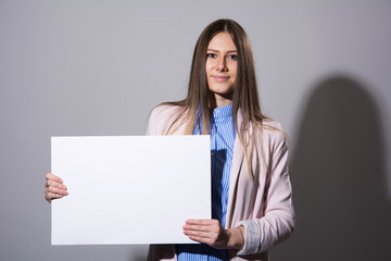 Young beautiful woman in a jacket with blank sheet