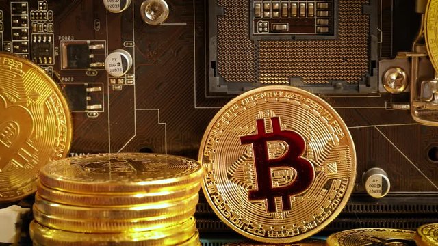 Gold Bit Coin BTC coins on the motherboard. Bitcoin is a worldwide cryptocurrency and digital payment system called the first decentralized digital currency.