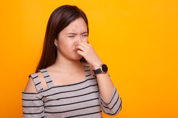 Young Asian woman  holding her nose because of a bad smell.