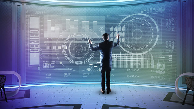 Huge screen. Clever careful experienced programmer checking the newest security program while standing in front of a large futuristic screen and touching necessary parts of it